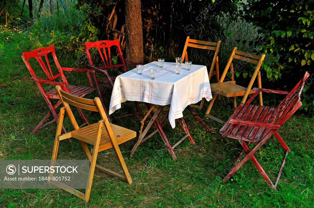 Garden table with glasses and chairs in the evening light, Eckental, Middle Franconia, Bavaria, Germany