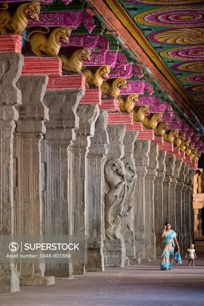 Woman with a child in a hall with brightly painted pillars, mythical creatures, Meenakshi Amman Temple or Sri Meenakshi Sundareswarar Temple, Madurai,...