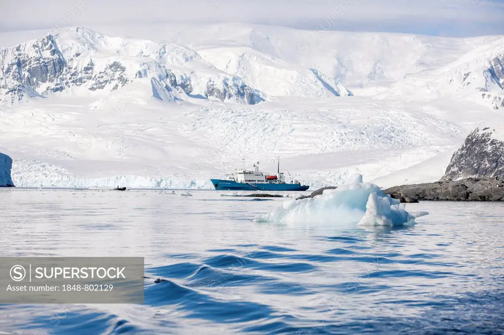 Snow-covered mountains, rocks, Russian research ship, Antarctic Peninsula, Antarctica