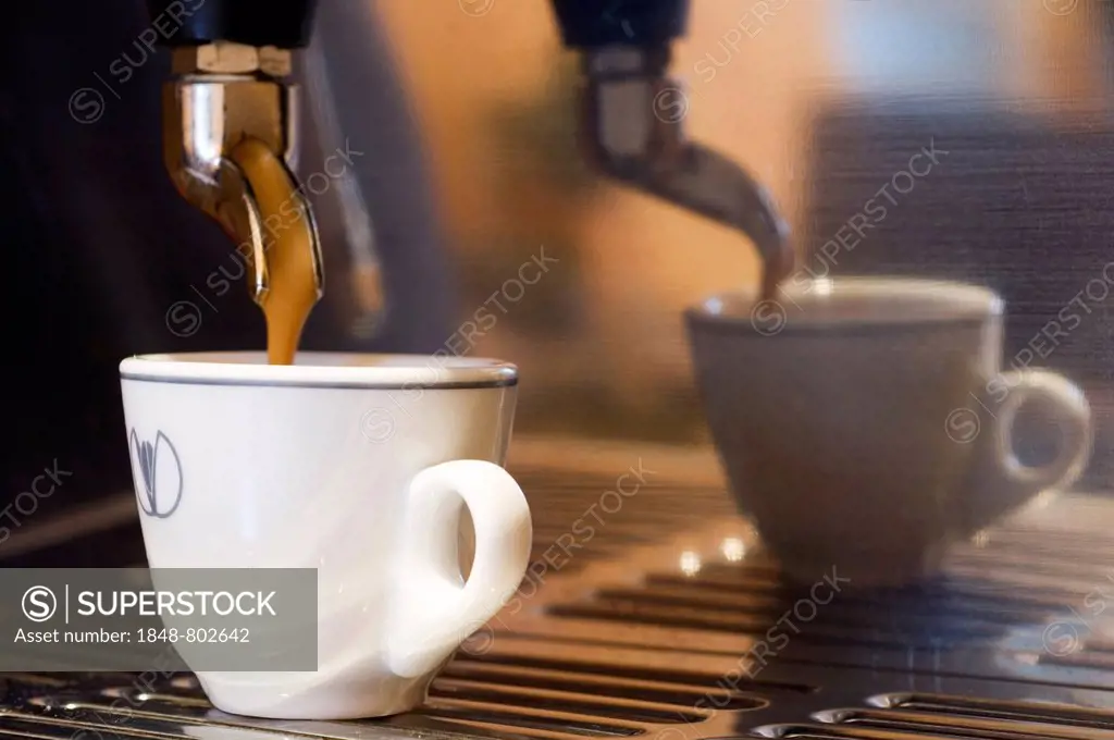 A cup of coffee is prepared with an espresso machine