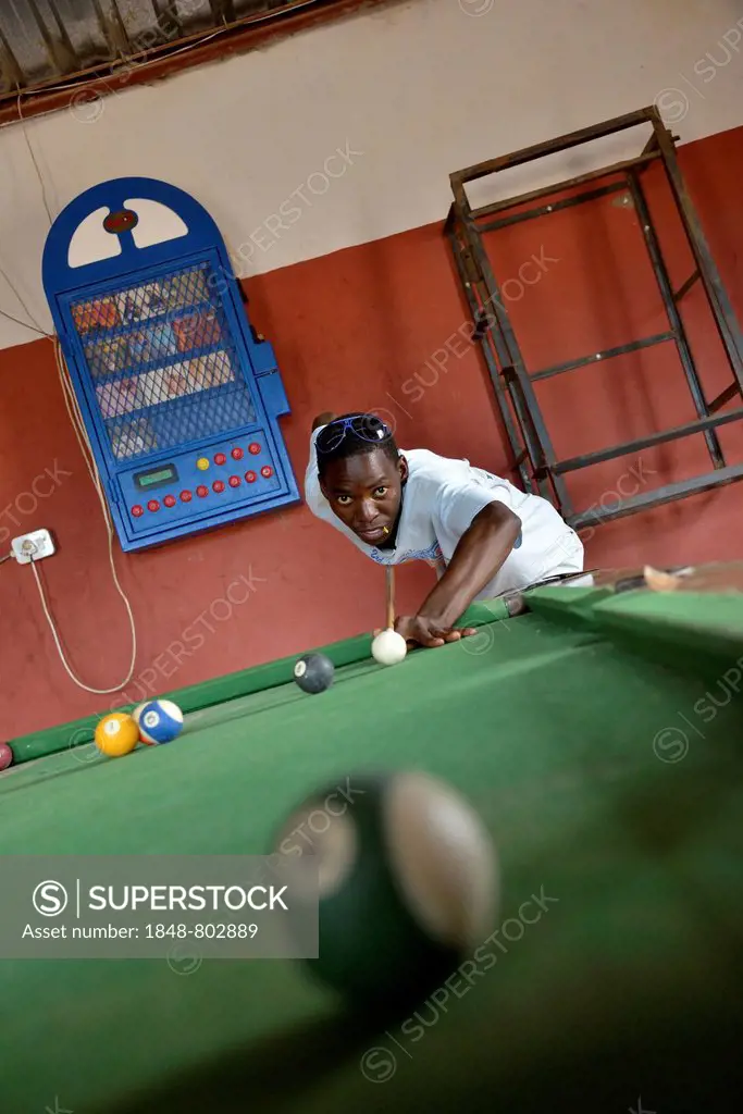 Young Himba man playing billiards in a bar