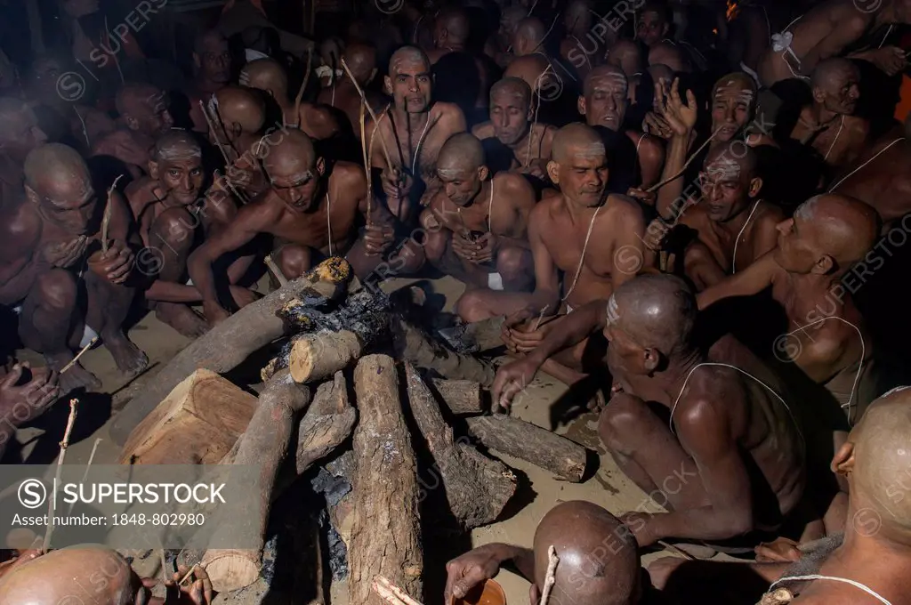 Sitting around a bonfire and chanting mantras as part of the initiation of new sadhus, during Kumbha Mela festival