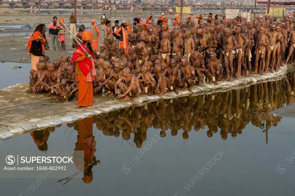 New sadhus getting orders from gurus as part of their initiation, at the Sangam, the confluence of the rivers Ganges, Yamuna and Saraswati, during Kum...