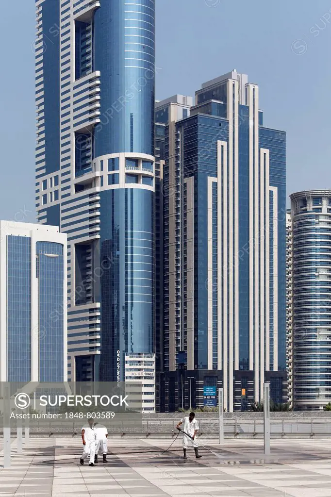Workers cleaning a terrace in front of skyscrapers with a high pressure washer, Sheikh Zayed Road, Dubai, United Arab Emirates, Middle East, Asia