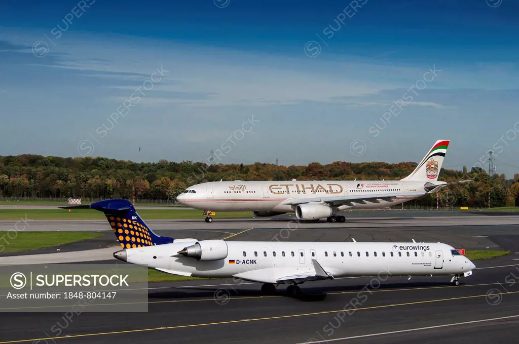 Two aircrafts on the runway, Bombardier CRJ900 of EuroWings, behind Airbus A330-343x of the Ethihad Airways, Düsseldorf International Airport, North R...