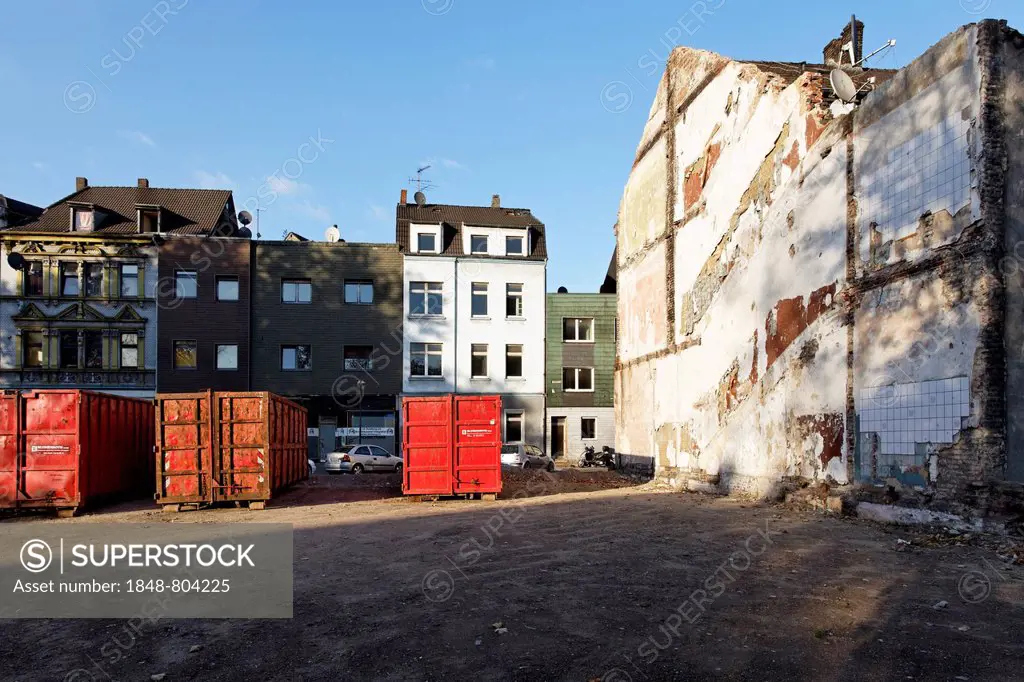Containers for construction debris in front of houses marked for demolition, neighborhood redevelopment, green belt project, Duisburg-Bruckhausen, Ruh...