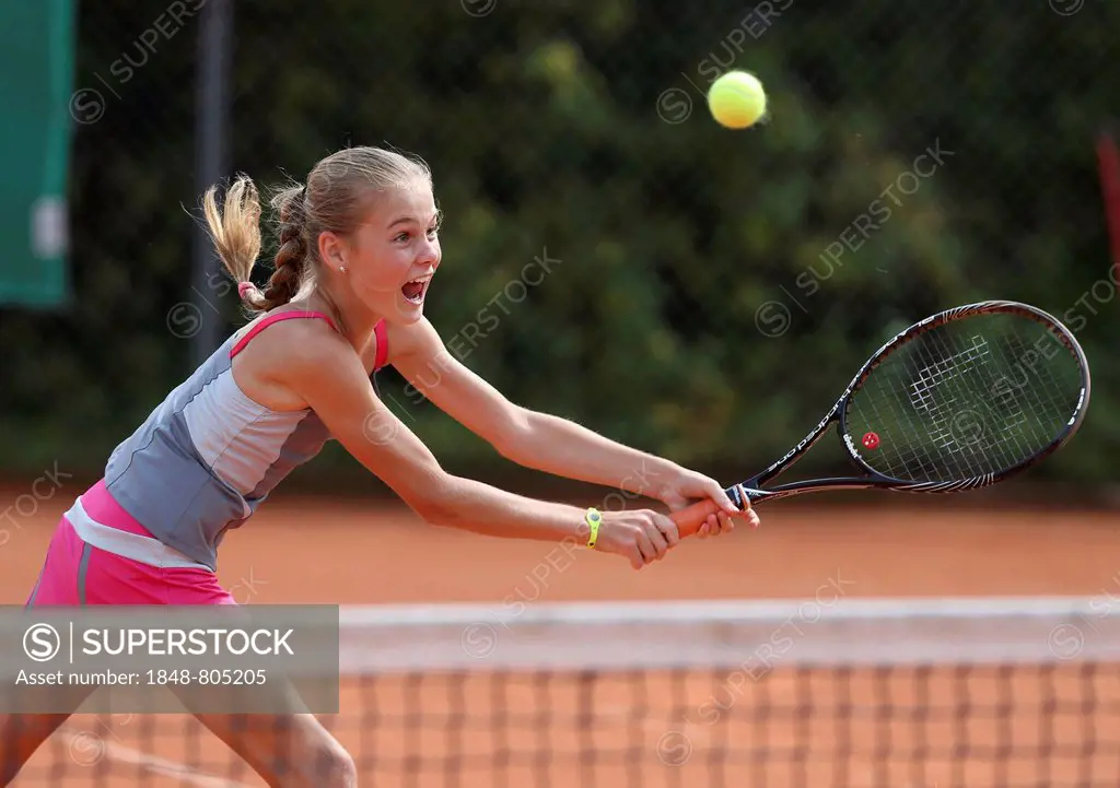 Girl, 11, playing tennis, hitting a backhand volley, Munich, Upper Bavaria, Bavaria, Germany