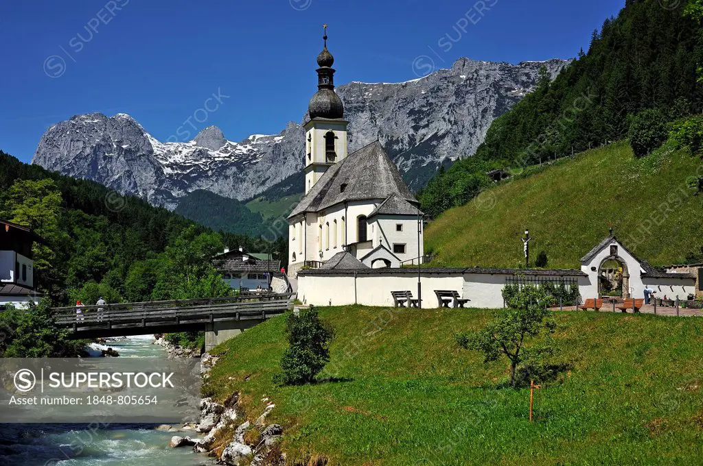 St. Sebastian Parish Church, built in 1512, with Ramsauer Ache stream, in front of the Reiter Alps, historic cemetery on the right, Ramsau bei Berchte...