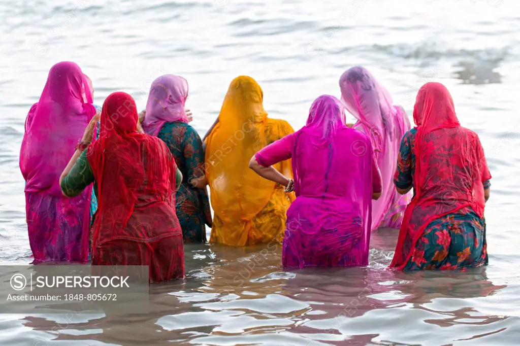 Hindu pilgrims, women in colourful saris taking a holy bath om the sea before sunrise, at the Ghat Agni Theertham, Rameswaram, Pamban Island, Tamil Na...