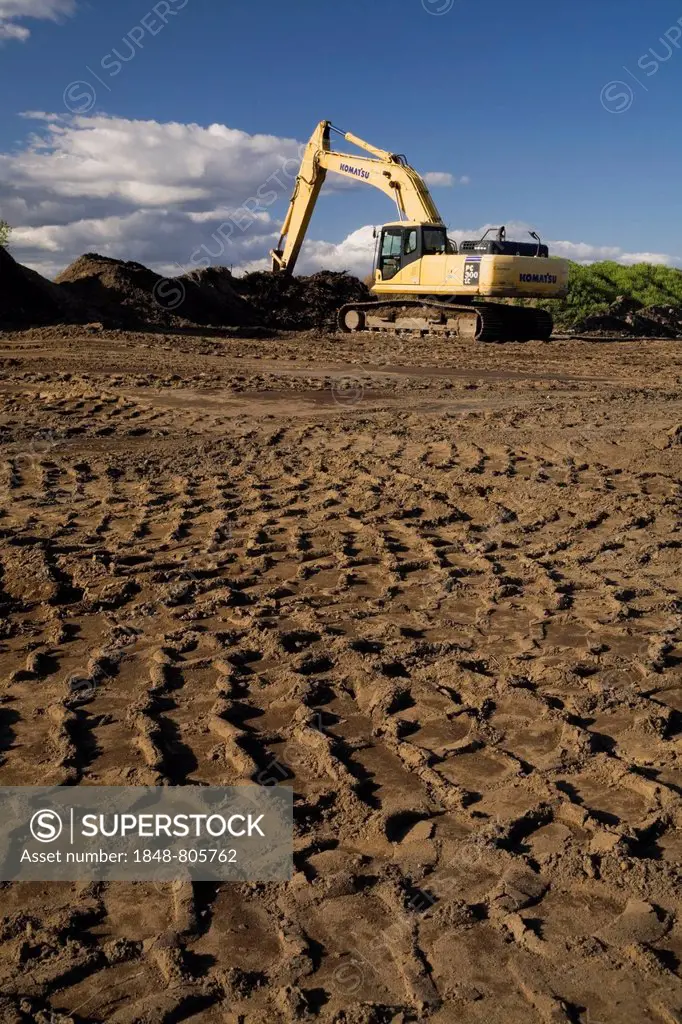 Heavy tire tracks and excavator in a commercial sandpit, Quebec City, Quebec Province, Canada