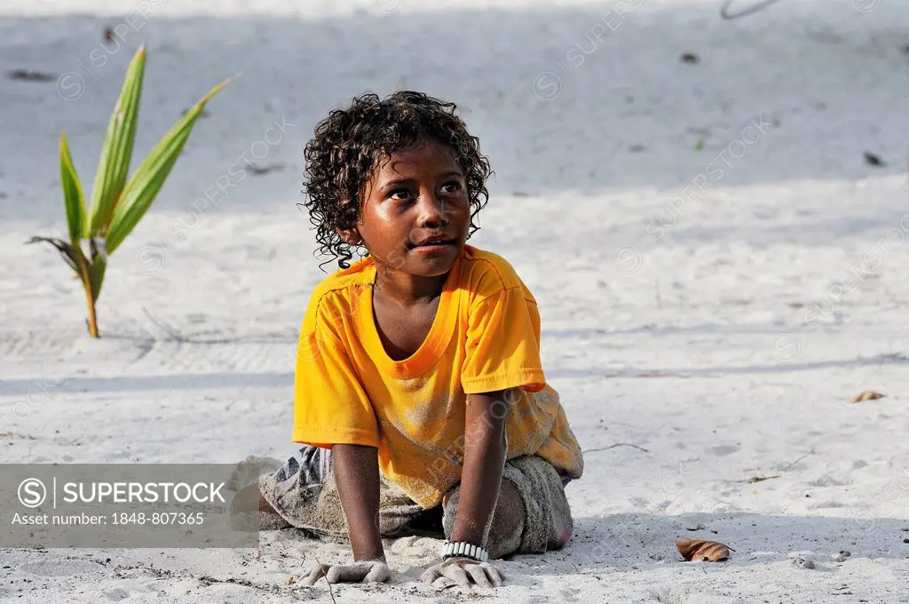 Local girl playing in the sand, Arborek, Raja Ampat, West Papua, Indonesia