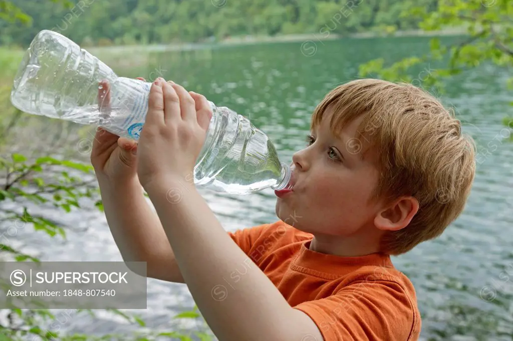 Boy drinks water from a plastic bottle, Plitvice Lakes National Park, Croatia