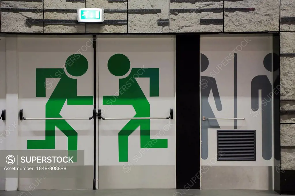 Emergency exit and toilet pictograms on doors in the station at the airport, Brussels, Brussels Region, Belgium