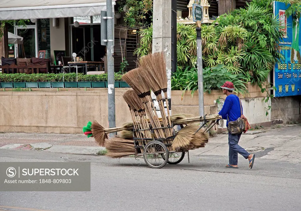 Broom merchant pushing his wares through the streets, Nimmana Haeminda, Chiang Mai, Chiang Mai Province, Thailand