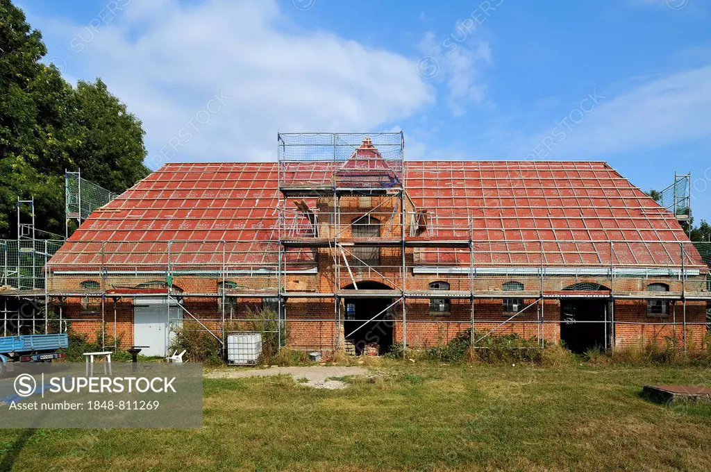 Old stables, 1921, with scaffolding for renovation, Othenstorf, Mecklenburg-Western Pomerania, Germany