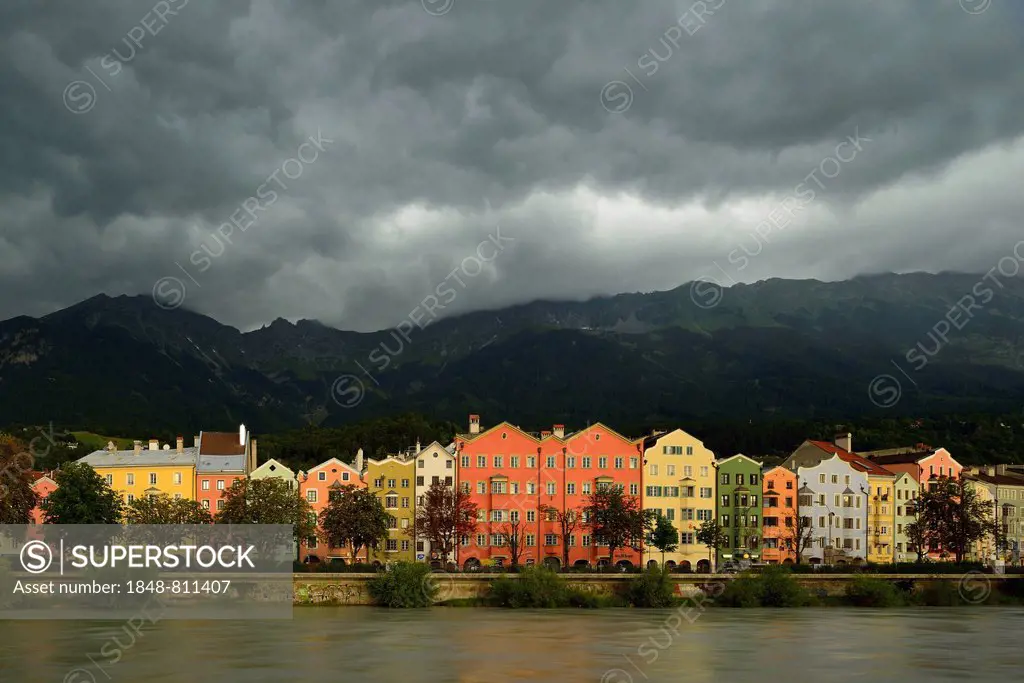 Buildings along the Inn river with dramatic clouds, Innsbruck, Tyrol, Austria