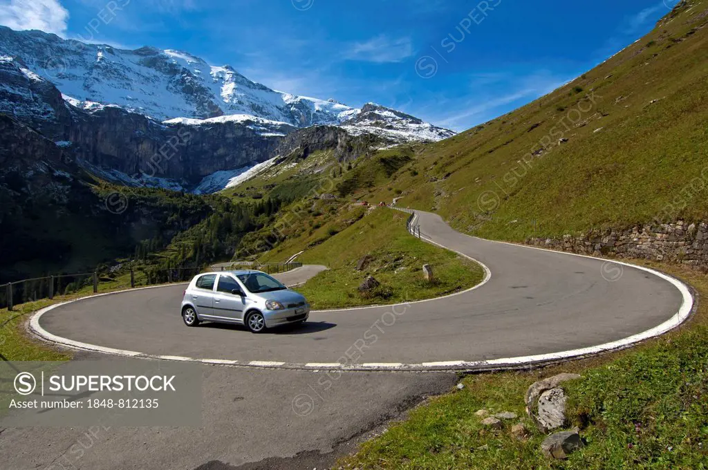 Car in a hairpin curve, mountain road to the Klausen Pass in front of the Glarus Alps, Urnerboden, Canton of Uri, Switzerland