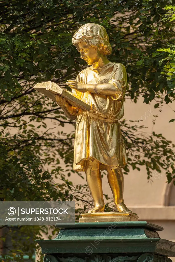 Gold plated fountain sculpture Boy Reading in front of the former secondary school, now a music school, Weimar, Thuringia, Germany