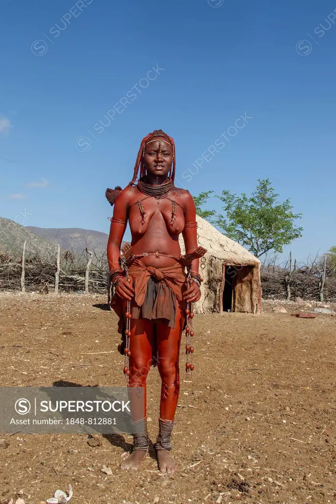 Young Himba woman standing in her village, Kaokoland, Kunene, Namibia