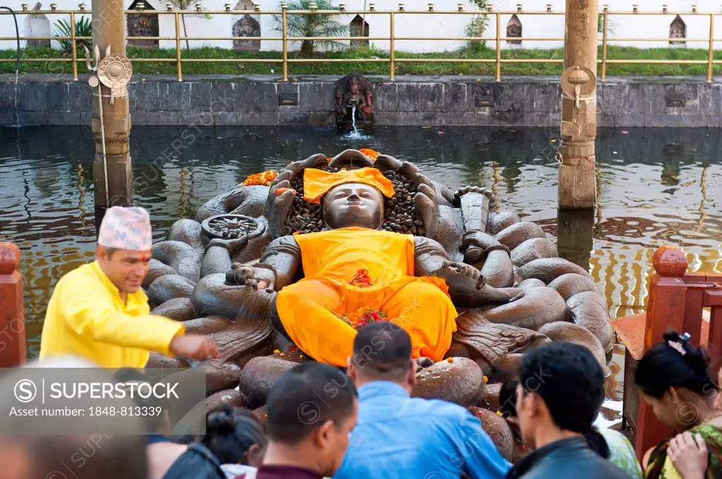 Hindu pilgrims and a brahman at a depiction of Lord Vishnu as Jalashayana Narayan lying in the water, Budhanilkantha, Kathmandu District, Bagmati Zone...