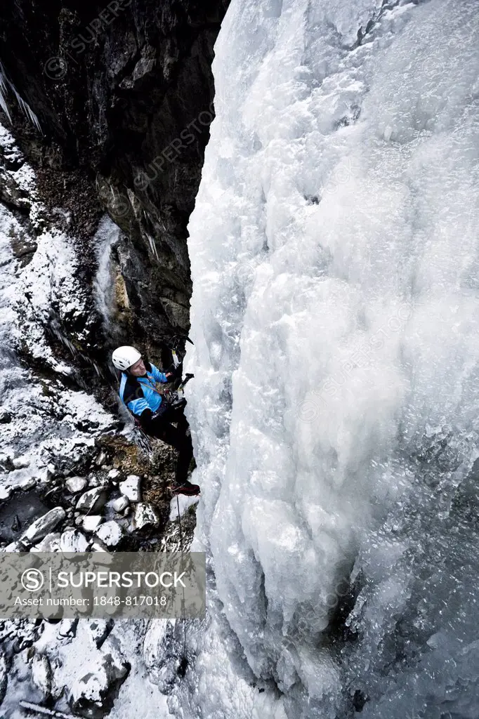 Ice climber climbing a frozen waterfall, Alpbach, Alpbachtal valley, Reith im Alpbachtal, Tyrol, Austria