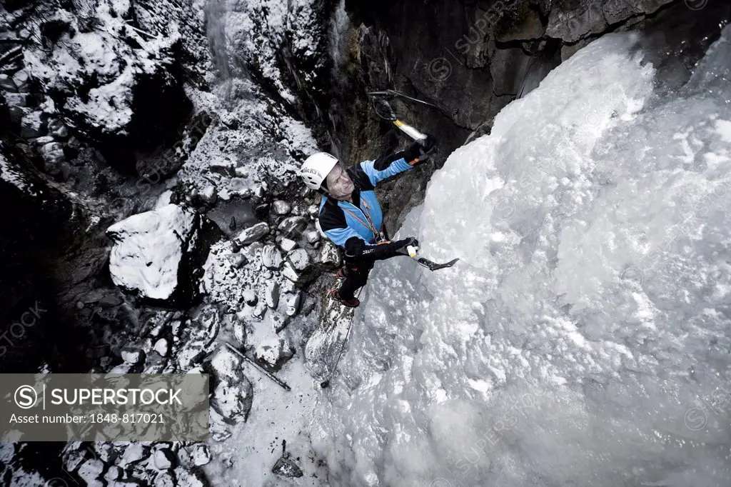 Ice climber climbing a frozen waterfall, Alpbach, Alpbachtal valley, Reith im Alpbachtal, Tyrol, Austria