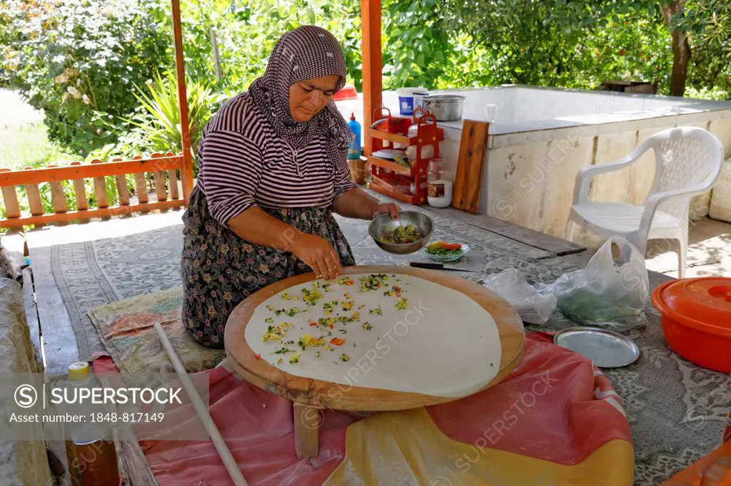 Woman spreading the filling on Goezleme flatbread, Anatolian cuisine, Antalya Province, Turkey