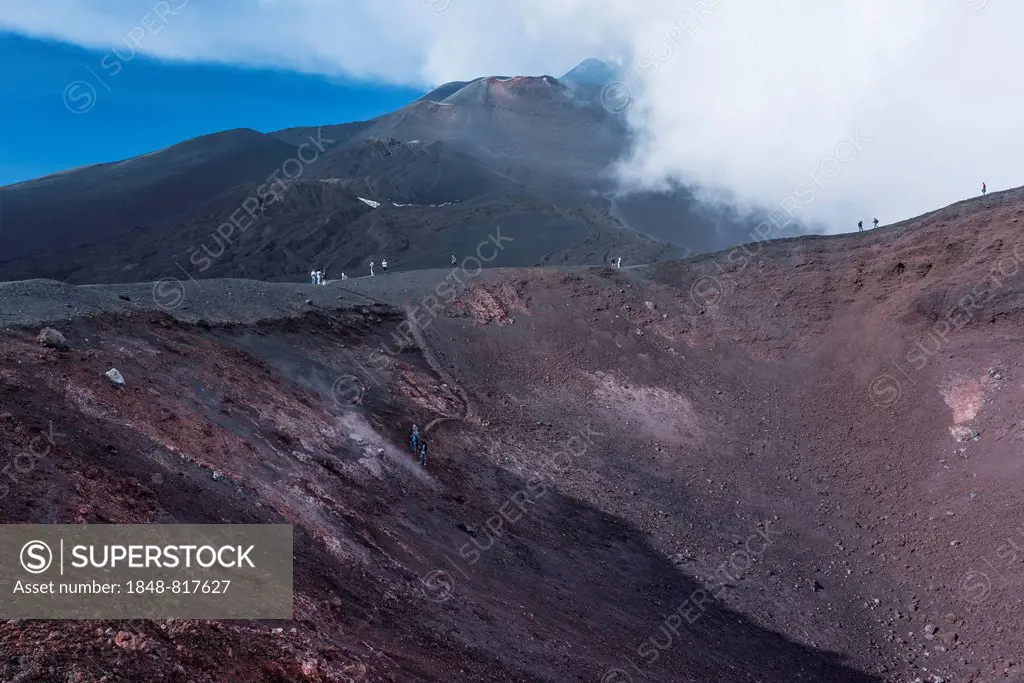 Tourists on the La Montagnola crater, lava fields behind, south side, Mount Etna in Zafferana, Sicily, Italy