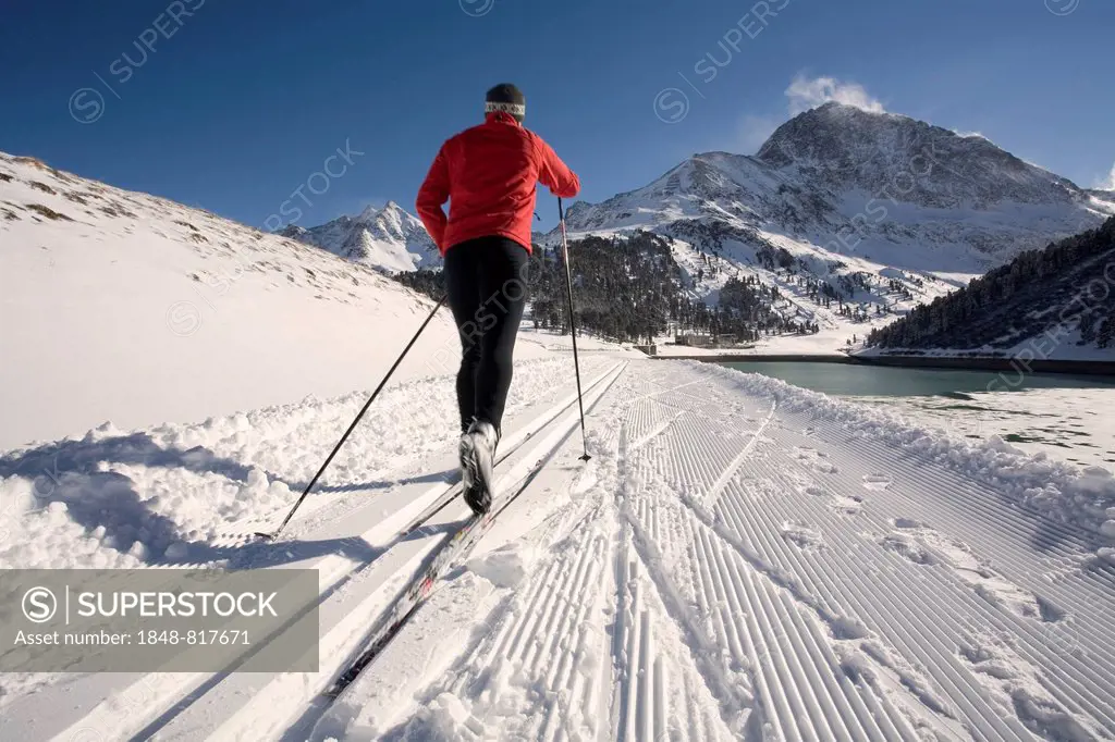 Cross-country skier, right the Laengental Reservoir, Kuehtai, Sellrain Valley, Tyrol, Austria