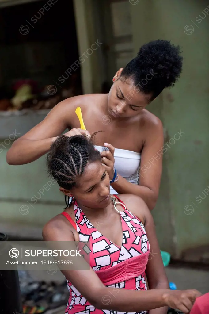 A woman dressing a girlfriend's hair, Praia, Santiago Island, Cape Verde