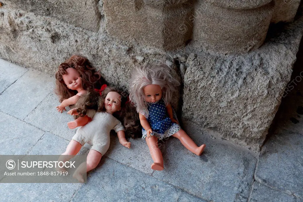 Three forgotten children's dolls beside a medieval column, Knight Street or Odós Hippotón, historic town centre, Rhodes, Island of Rhodes, Dodecanese,...