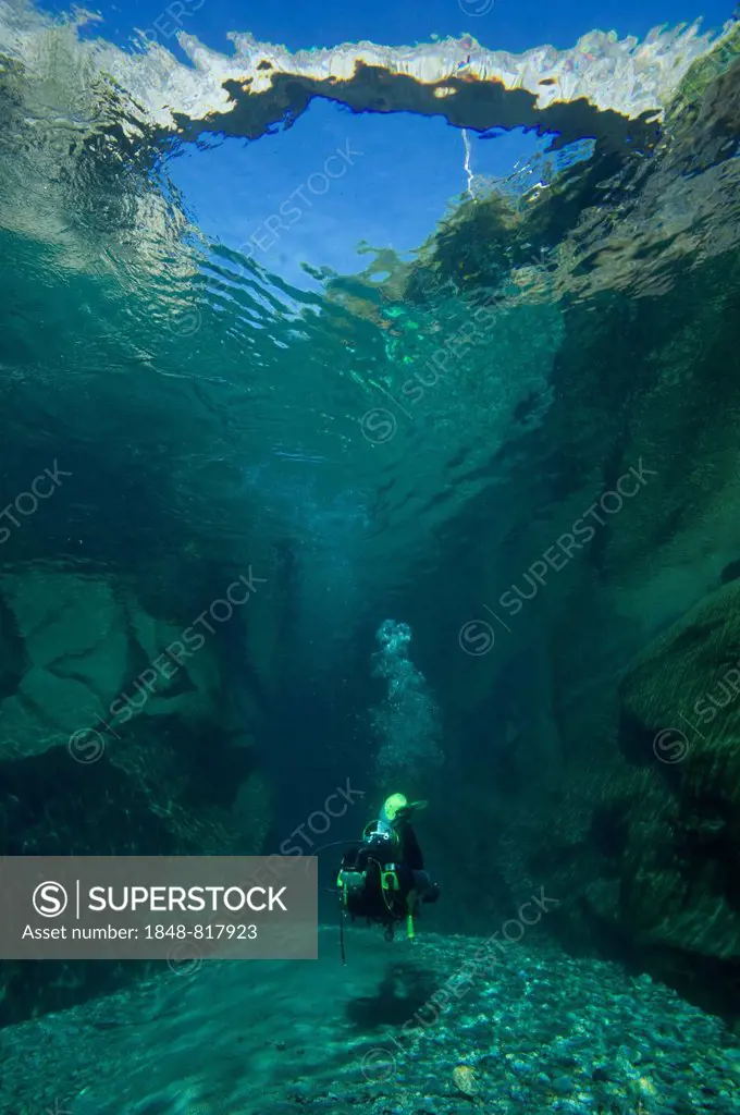 Scuba diver diving below the bridge of Ponte dei Salti, Lavertezzo, Canton of Ticino, Switzerland