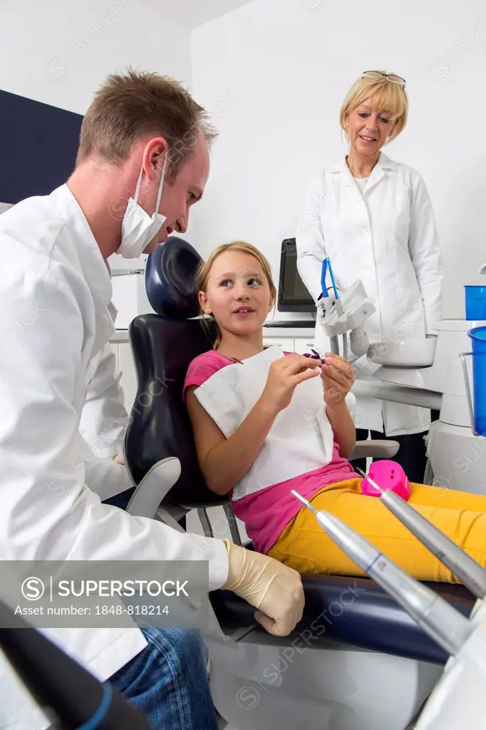 Girl at the dentist, dentist discussing further treatment with the patient, Germany