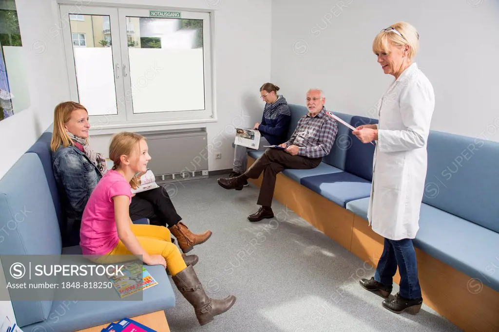 Receptionist calling for the next patient in the waiting room of a dental office, Germany