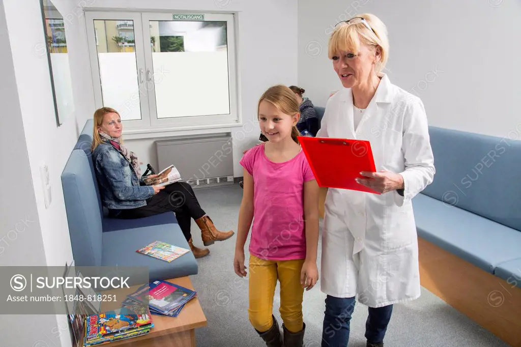 Receptionist with a patient in the waiting room of a dental office, Germany