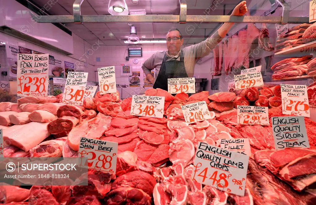 Butcher behind his display, Leeds Kirkgate Market, Leeds, West Yorkshire, England, United Kingdom