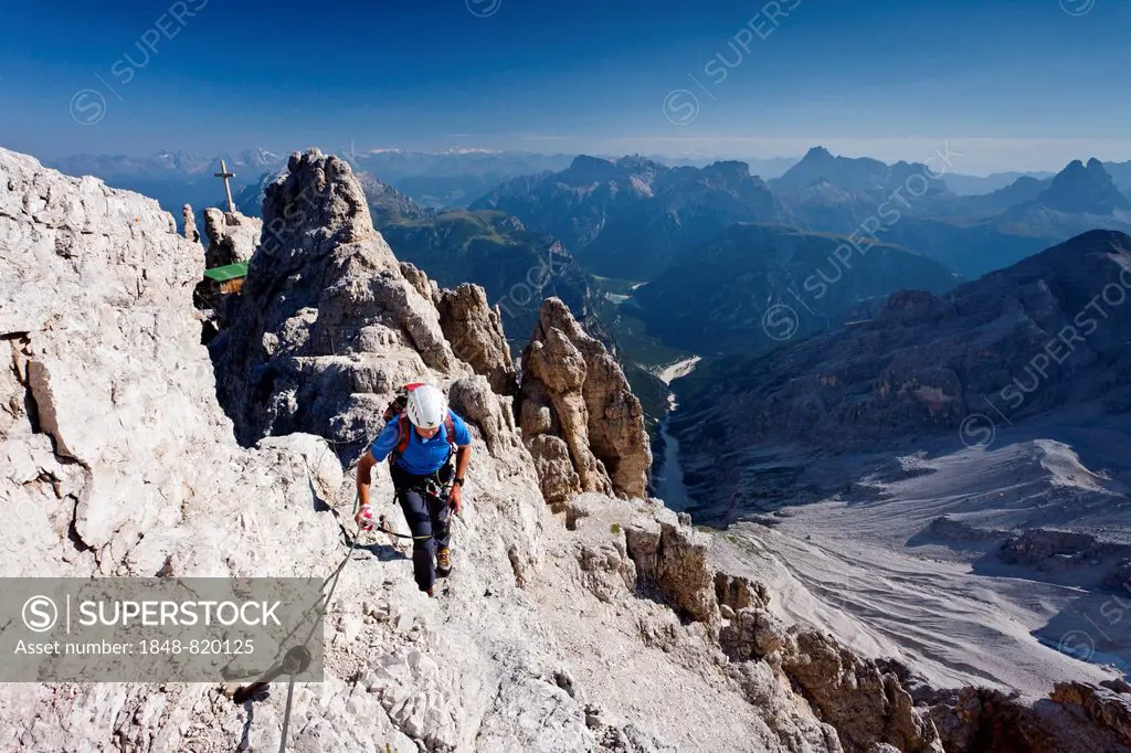 Mountain climber ascending the Via Ferrata Marino Bianchi climbing route on Cristallo di Mezzo Mountain, Dolomites, Belluno, Italy