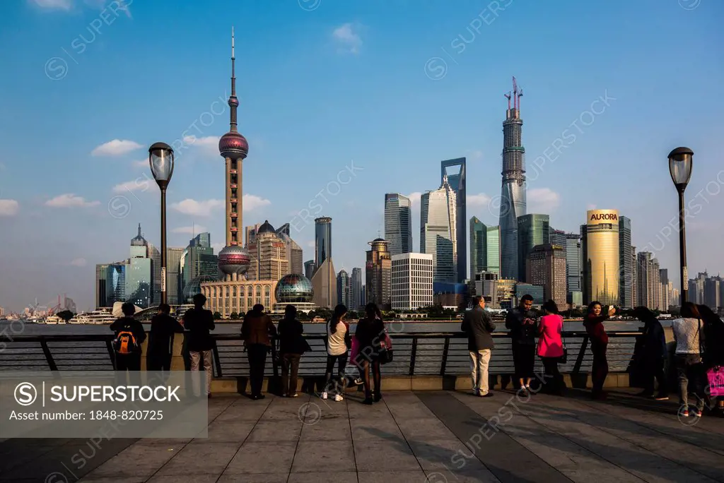 Tourists in front of the Pudong skyline with Oriental Pearl Tower, Shanghai World Financial Center and Shanghai Tower, from the Bund, Shanghai, China