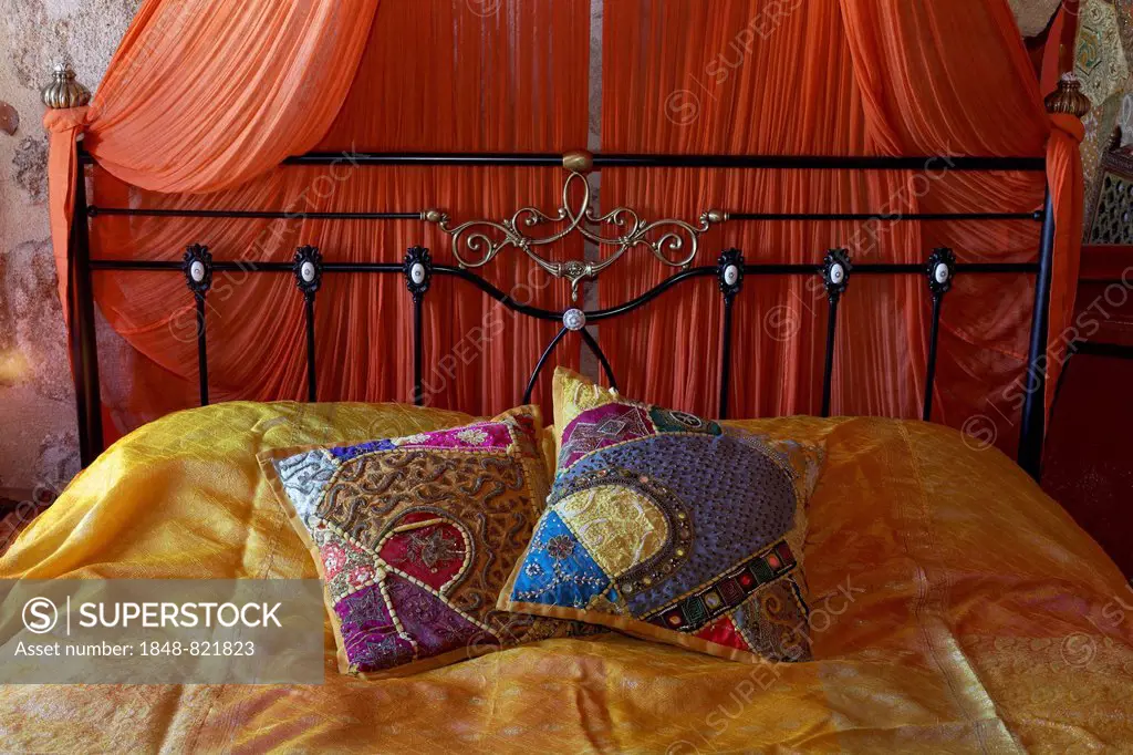 Romantic metal bed with canopy and two oriental silk cushions, Nikos Takis Fashion Hotel, Rhodes, Rhodes island, Dodecanese, Greece