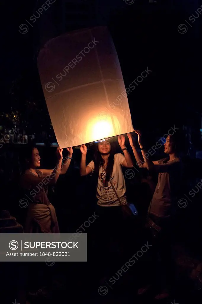 Young people releasing a sky lantern or Kongming lantern, Chiang Mai, Thailand