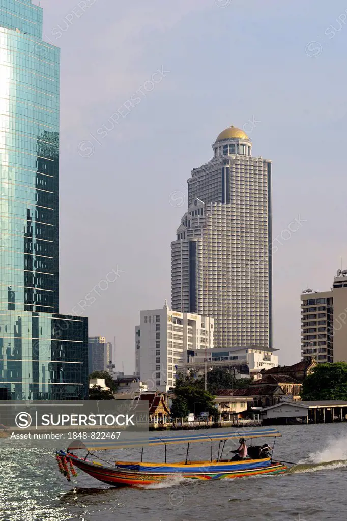 Long-tail boat on the Chao Phraya River with the State Tower at back, Bangkok, Thailand