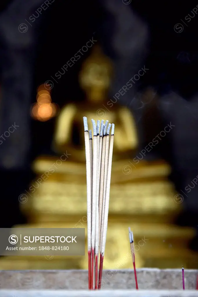 Burning incense sticks in front of a Buddha statue, Wat Traimit Temple, Bangkok, Thailand