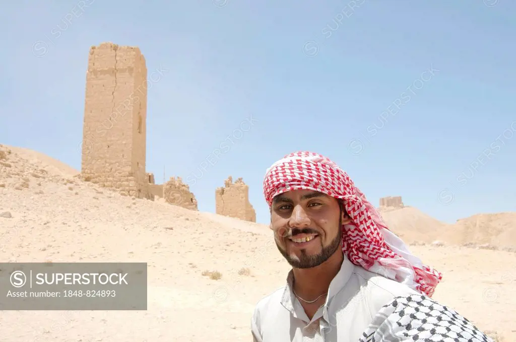 Bedouin, a tower tomb in the back, ancient city of Palmyra, Palmyra District, Homs Governorate, Syria