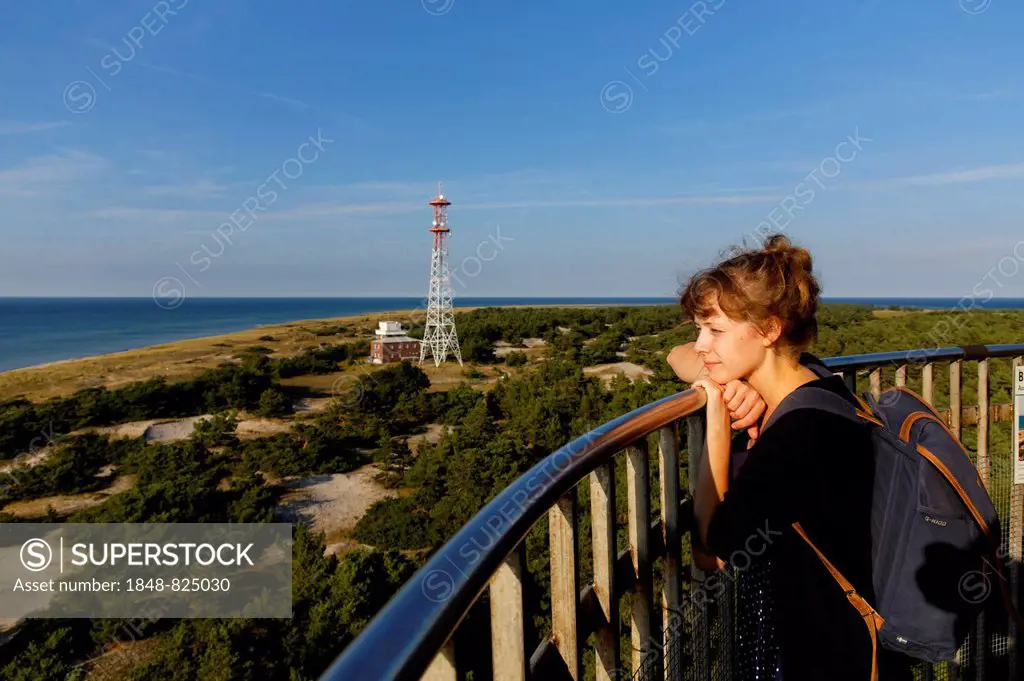 Young woman looking out from the Leuchtturm Darßer Ort lighthouse, Darß, Western Pomerania Lagoon Area National Park, Mecklenburg-Vorpommern, Germany