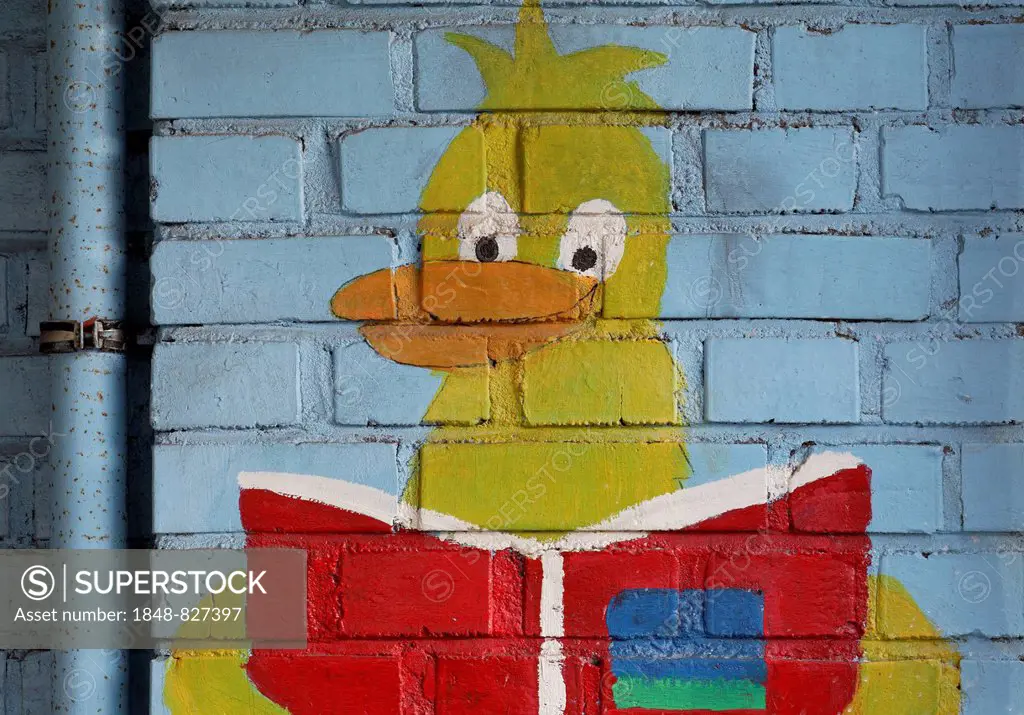 Duck figure reading a book, mural in a school playground, Germany