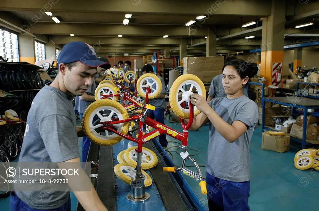Woman testing children's bicycles in a factory, Asuncion, Paraguay, South America