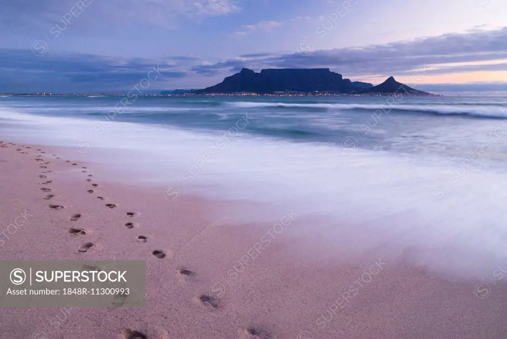 Table Mountain, Lion's Head and Devil's Peak in the evening light, panoramic view of Cape Town, footprints on Bloubergstrand beach, Table Bay in the A...