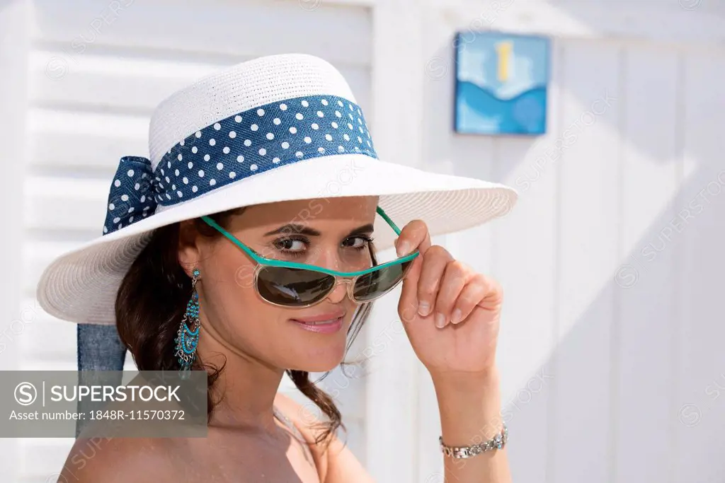 Woman with hat looking over the rim of her sunglasses, Adriatic, Senigallia, Province of Ancona, Marche, Italy