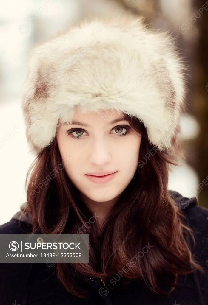 Young woman wearing a fur hat in winter, portrait