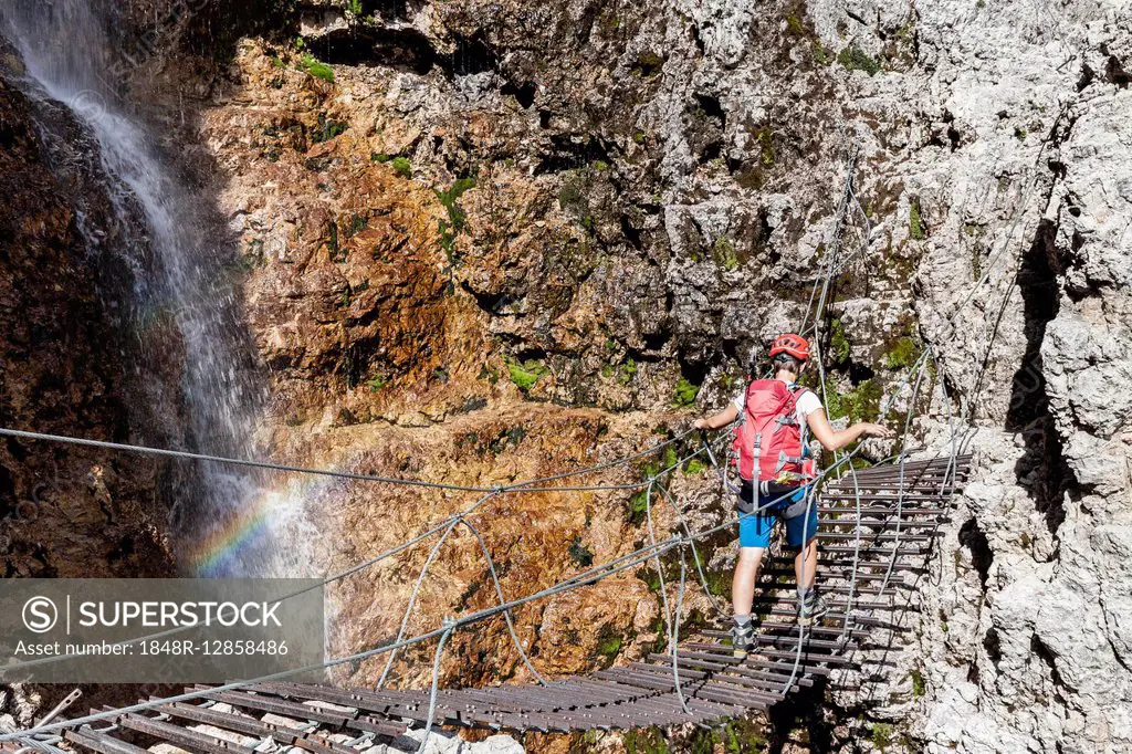 Climbers on suspension bridge, with waterfall, via ferrata Vallonsteig, Piz Boé, Sella, Dolomites, Corvara, Province of South Tyrol, region of Trentin...